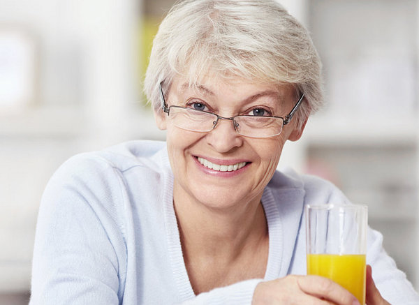 elderly woman holding a glass of juice